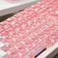 Close-up of a transparent pink keyboard with red accents on a white surface.
