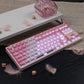 Pink and white keyboard on a dark surface with decorative elements.