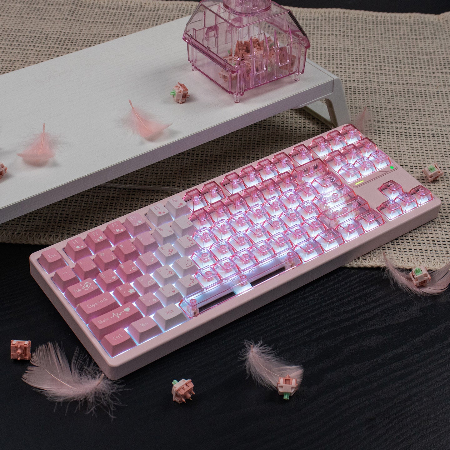 Pink and white keyboard on a dark surface with decorative elements.