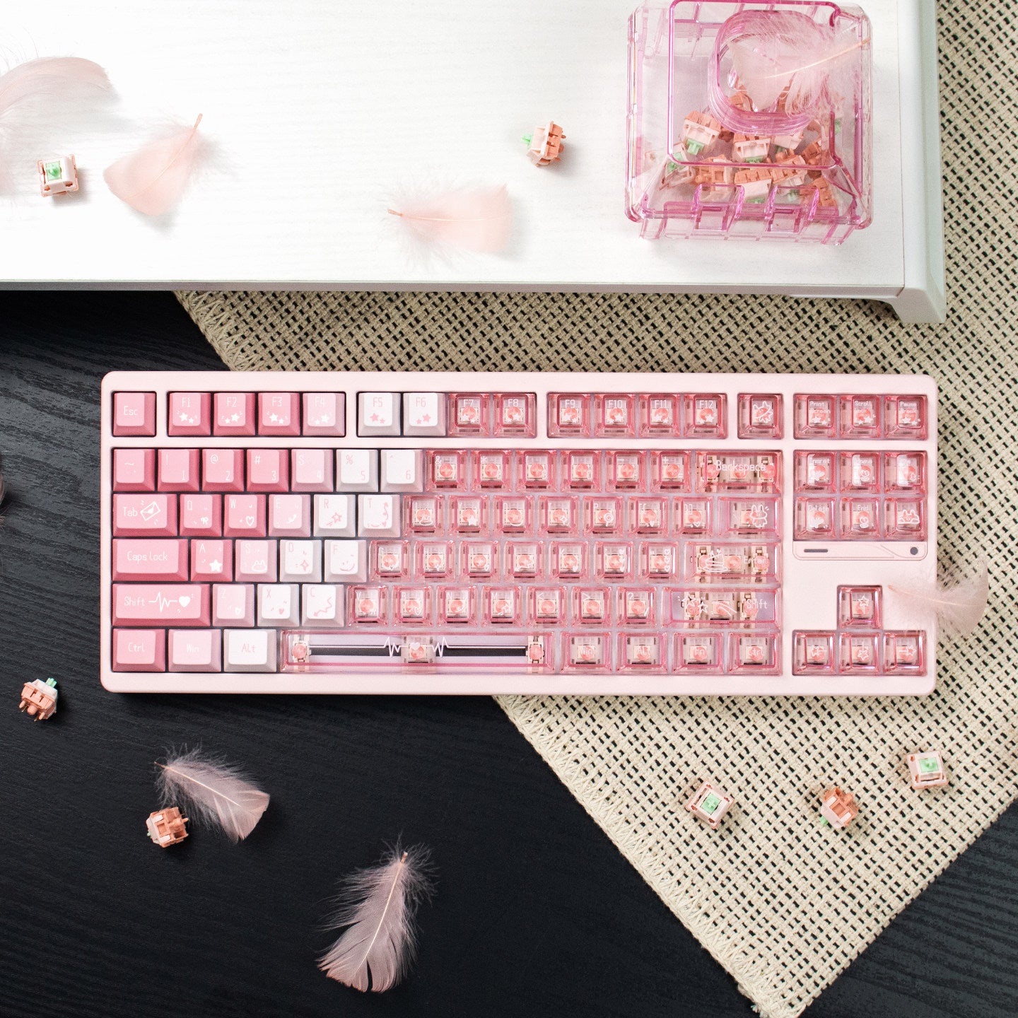 Pink and white keyboard on a desk with decorative items