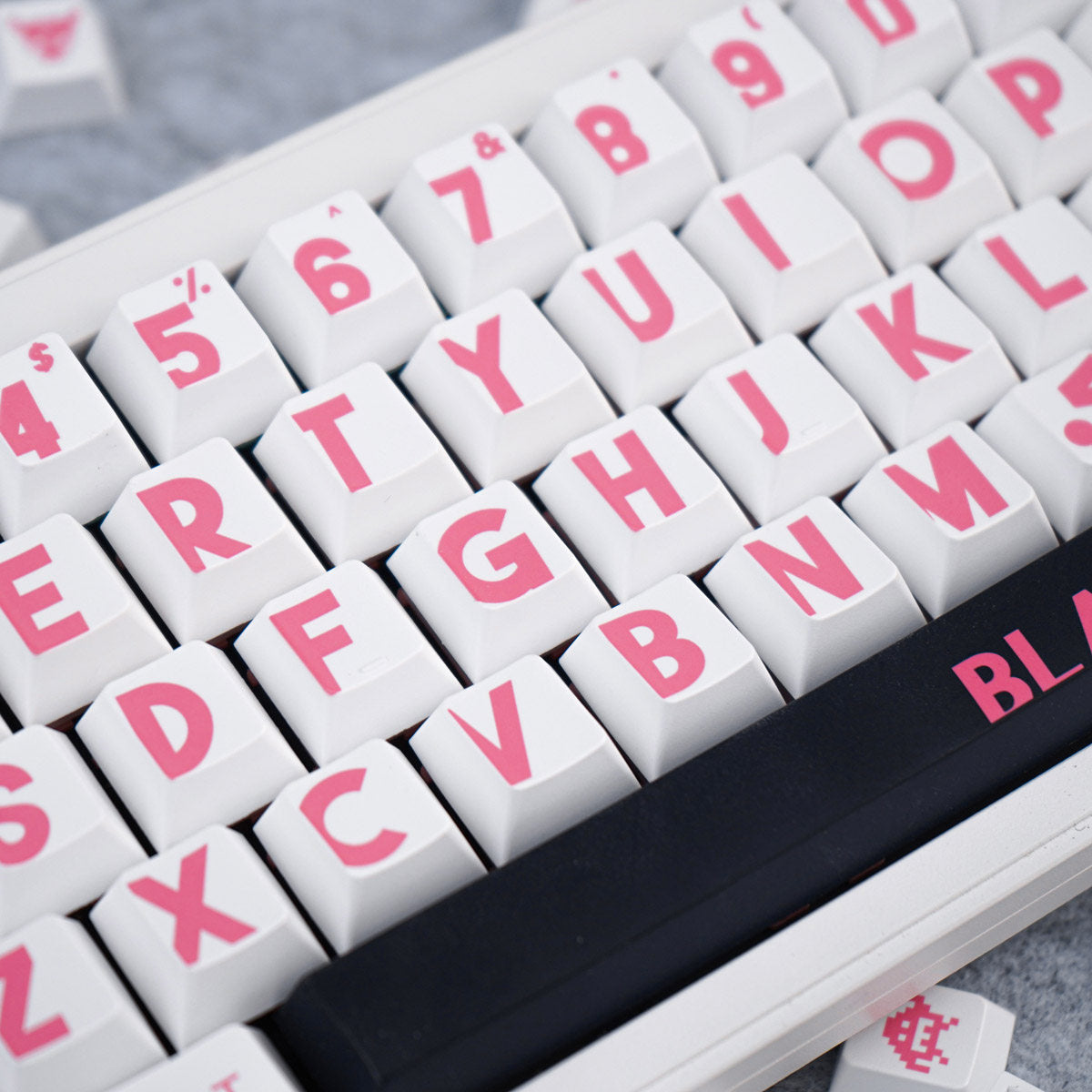 Close-up of a keyboard with pink lettering on white keys