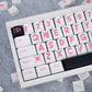 Close-up of a keyboard with pink lettering on a gray surface