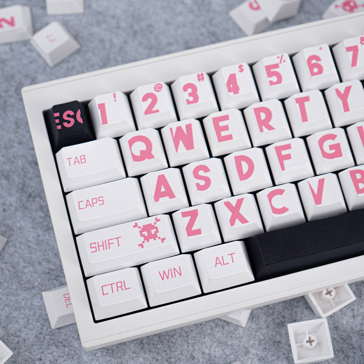 Close-up of a keyboard with pink lettering on a gray surface