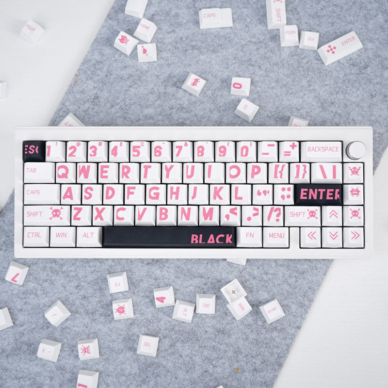 Keyboard with pink lettering on a gray surface with scattered keycaps.